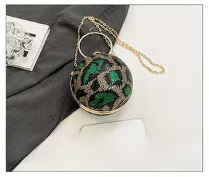 Detail of glitter leopard print sphere evening bag with metal ring handle and chain strap