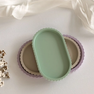Three oval trays with wavy edges in mint green, light purple, and beige stone finish