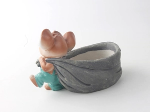 Dettaglio del vaso in resina a forma di topo con salopette verde e borsa grigia