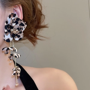 Macro detail of bohemian leopard print fabric flower earrings with long tassel chains