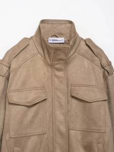 Close-up of khaki suede jacket collar with epaulettes and buttoned chest pocket