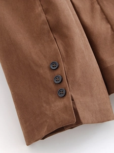 Detail of brown corduroy blazer sleeve with three dark brown buttons and fine stitching