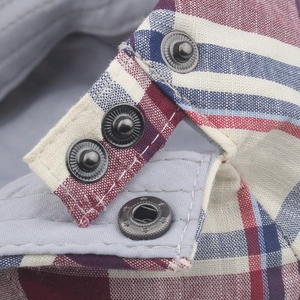 Macro detail of red and blue checkered cotton hat with vintage metal button and lining