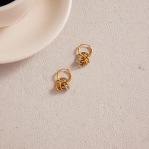 Detail of two-tone gold and silver multi-ring hoop earrings with twisted rope texture