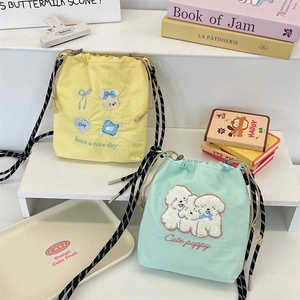 Detail of cute embroidered canvas bucket bags with drawstring closure and striped straps