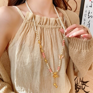 Detail of a vintage Chinese style long necklace featuring pearl tassel and butterfly pendant