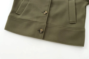 Détail de la veste en laine vert armée montrant le tissu, le bouton et la poche