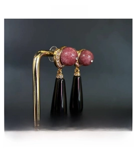 Detailed view of vintage long drop earrings with pink marble bead and black teardrop pendant