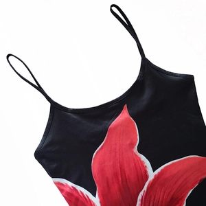 Close-up of black bodycon dress featuring vivid red flower print and slim spaghetti straps