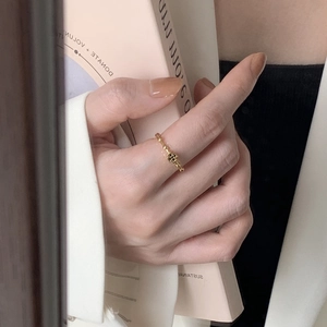 Close-up of a minimalist gold 925 silver ring with a clover motif worn on a finger