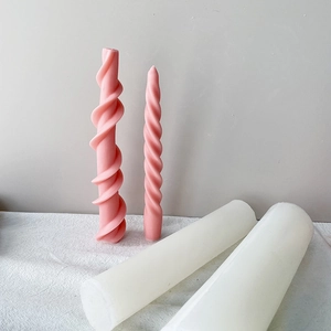 Detail view of pink spiral and white pillar candles on elegant draped fabric