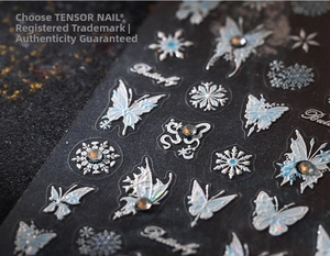 Detailed macro view of 3D embossed butterfly and snowflake nail stickers with rhinestones