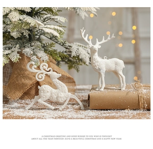 Detailed view of two white flocked reindeer decorations on a festive gift box