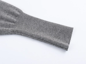 Detailed close-up of grey knitted cardigan sleeve with high-quality ribbed cuff texture