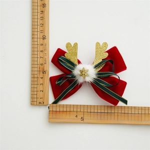 Christmas bow hair clip with red velvet, green ribbon and golden elk antlers on white background
