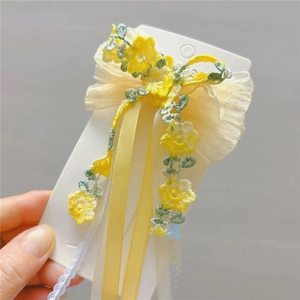 Floral embroidered girls hair clip with yellow flower and ribbons on display card