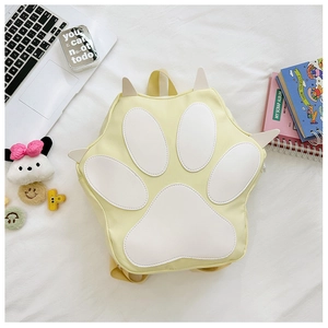 Flat lay of a yellow cat paw student backpack with creative 3D claw details and stationery