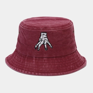 Detail of burgundy washed canvas bucket hat featuring white hand embroidery and metal eyelets