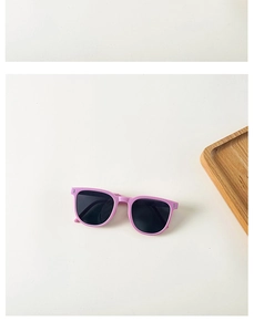 Flat lay of purple foldable kids sunglasses with black polarized lenses on a tray