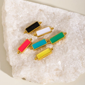 Set of six colorful rectangular enamel pendants with gold metal frames on white stone