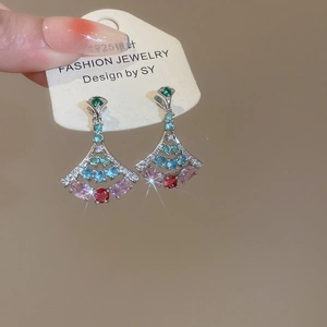 Macro shot of silver fan-shaped earrings inlaid with vibrant colorful zircon gemstones