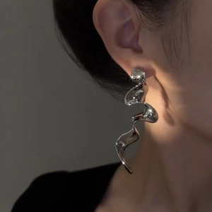 Minimalist silver ribbon fringe earrings with polished finish on model's profile