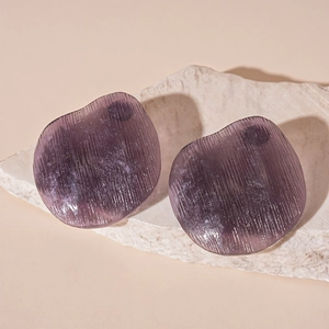 Detailed macro view of purple irregular resin stud earrings with vertical striped texture