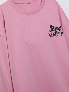 Detailansicht des rosa Langarm-T-Shirts mit schwarzem Drachendruck und Logo-Schrift