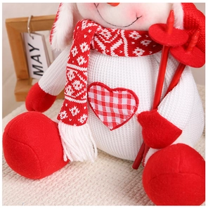 Close-up of a Christmas snowman plush with red knitted scarf and ski accessories