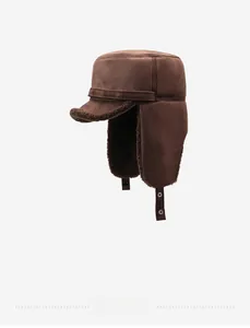 Detail view of winter brown suede trapper hat with thick faux fur lining and ear flaps
