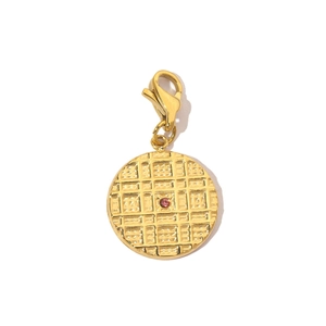 Macro shot of gold stainless steel Evil Eye charm with pink zircon and lobster clasp