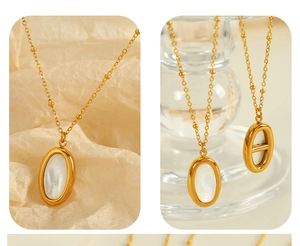 Detailed view of oval white shell pendant on gold beaded satellite chain necklace