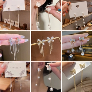 Collage of long tassel earrings featuring pearls, rhinestones, and gold-plated metal chains