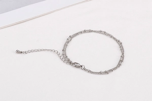 Detail of silver stainless steel curb chain with small beads and lobster clasp closure