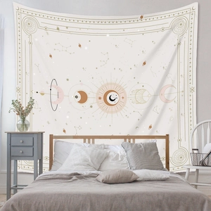 Détail d'une tapisserie céleste soleil et lune avec constellations sur un lit en bois