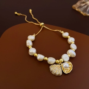 Elegant gold plated baroque pearl and shell bracelet with adjustable chain on leather