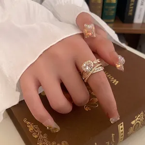 Elegant gold multi-layer stacking rings set with oval zircon crystals on vintage book