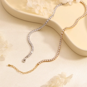 Detail of gold and silver tennis necklaces with zircons on a ceramic jewelry tray