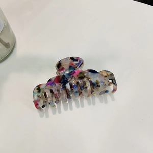 Detail of colorful cloud-shaped acetate hair claw clip with golden Barrette La France text