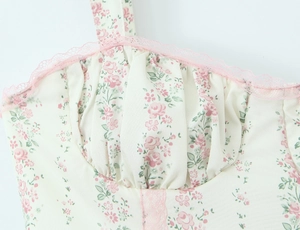 Dettaglio vestito floreale crema con bordo in pizzo rosa e bustino a pieghe