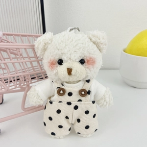 Simpatico portachiavi orsetto di peluche bianco con salopette a pois su sfondo bianco