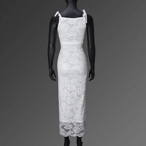 Detail showing the white lace texture and delicate back bow tie on a long summer dress
