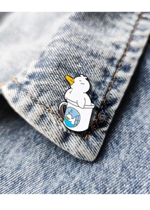 Detail of cute duck enamel pin attached to a light blue denim jacket collar