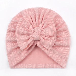 Close-up of pink knit baby turban hat featuring a large soft decorative bow