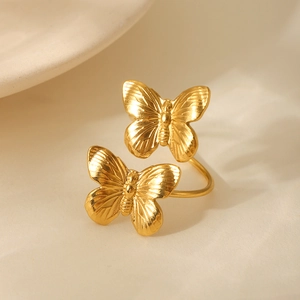 Detailed close-up of double butterfly open ring with polished gold finish and fine texture