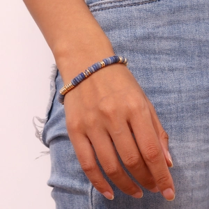 Détail d'un bracelet bohème avec pierres naturelles bleu clair et perles dorées à l'or 18K