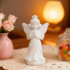 White angel statue praying with wings and crown home decor in cozy room setting