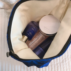 Interior view of blue floral canvas makeup bag showing spacious storage for skincare