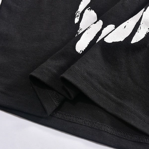 Gros plan sur un T-shirt noir en coton avec imprimé blanc et ourlet à double surpiqûre