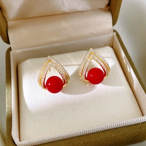 Vue détaillée des boucles d'oreilles plaquées or 18k avec pavage en zircon et perle rouge